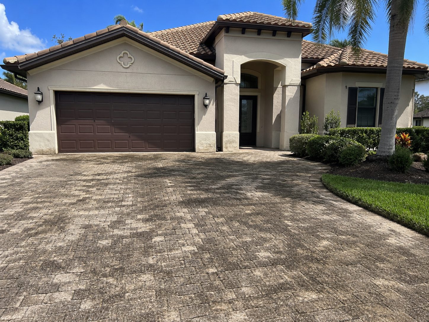 The same paver driveway before cleaning — dull, dirty pavers